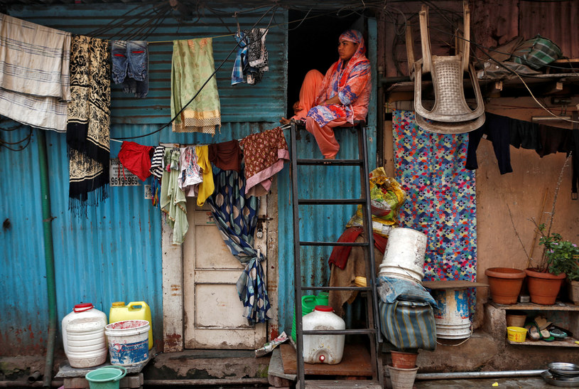 Mieszkanka jednej z dzielnic dla biednych w Indiach siedzi na drabinie przystawionej do swojego domu. /Francis Mascarenhas /Agencja FORUM