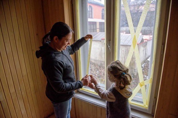 Mieszkanka Lwowa Olga ze swoją córką Emilią zaklejają taśmą okna swojego mieszkania /Vitaliy Hrabar /PAP