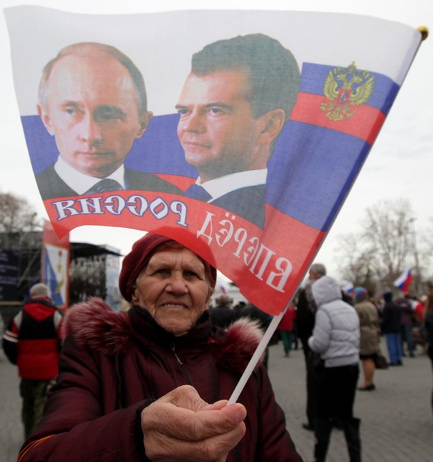 Mieszkanka Sewastopola z flagą z wizerunkami Władimira Putina i Dmitrija Miedwiediewa /ZURAB KURTSIKIDZE /PAP/EPA