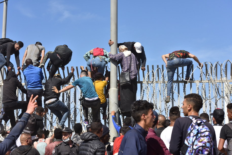 Migranci pokonujący ogrodzenie w mieście Al-Funajdik /Jalal Morchidi /PAP/EPA