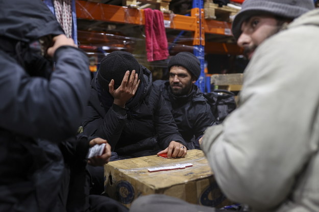Migranci w obozie po stronie białoruskiej, w hali magazynowej przy przejściu granicznym /STRINGER /PAP/EPA