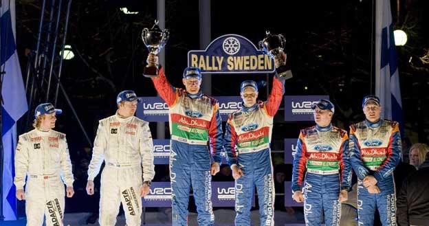 Mikko Hirvonen, Mads Ostberg, Jari-Matti Latvala oraz ich piloci na podium Rajdu Szwecji /AFP