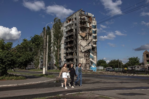 Młode kobiety na tle zniszczonego budynku w Borodziance w obwodzie Kijowskim /ROMAN PILIPEY /PAP/EPA