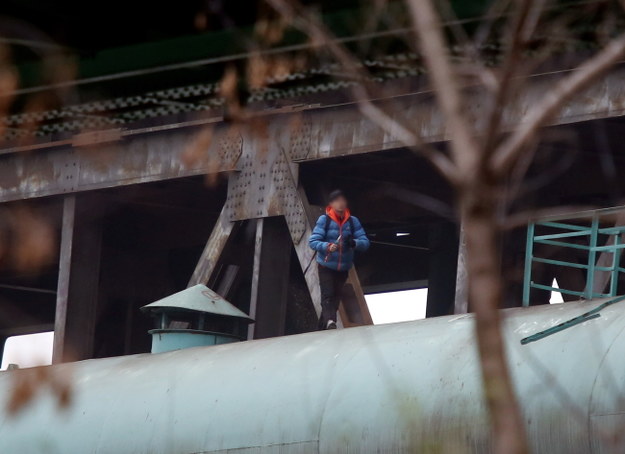 Młody mężczyzna wdrapał się na rurę biegnącą wzdłuż mostu kolejowego /Tomasz Gzell /PAP