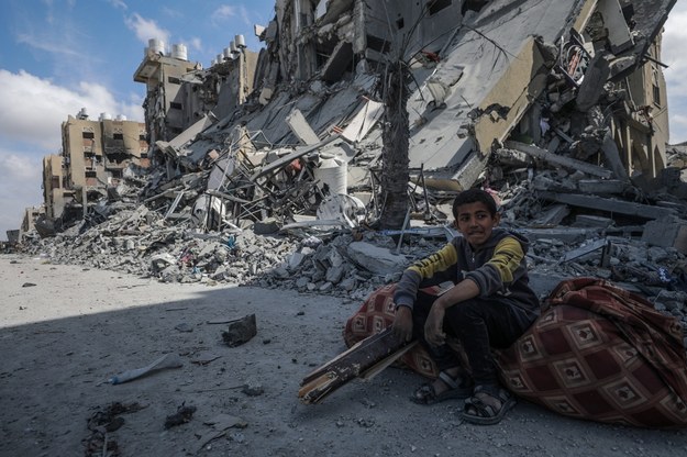 Młody Palestyńczyk siedzący koło zniszczonego domu w mieście Chan Junus w Strefie Gazy /MOHAMMED SABER  /PAP/EPA