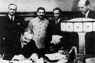 Mołotow, w obecności Stalina i Ribbentropa, podpisuje pakt niemiecko-radziecki o rozbiorze Polski, /Encyklopedia Internautica