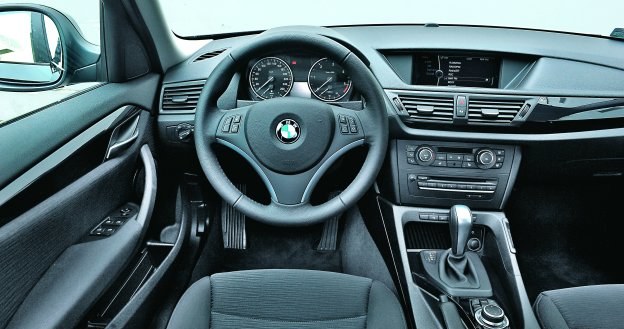 Na desce rozdzielczej BMW X1 dominują proste linie, kierownica świetnie leży w rękach. /Motor