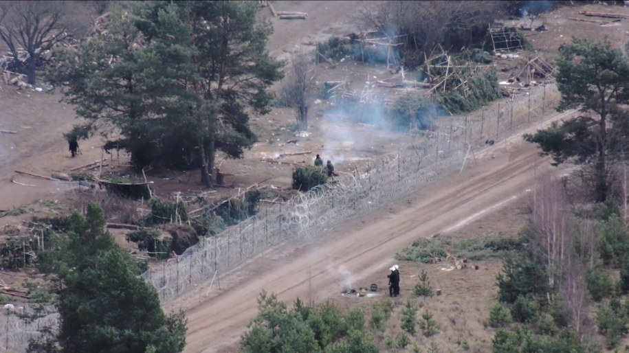 Na terenie koczowiska przy ogniu ogrzewają się jeszcze pojedyncze osoby. /Straż Graniczna /PAP