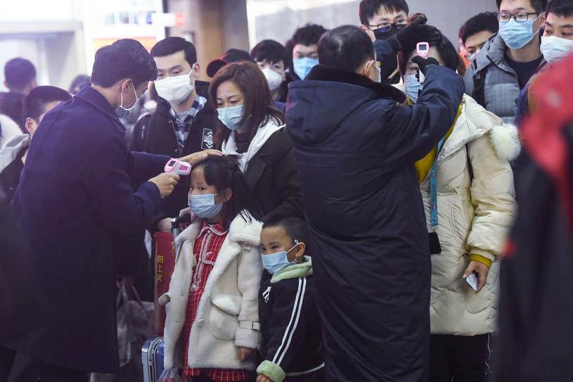 Na zdjęciu członkowie personelu sprawdzający temperaturę ciała pasażerów po dotarciu pociągu z Wuhan na dworzec kolejowy w Hangzhou /STR / AFP /AFP