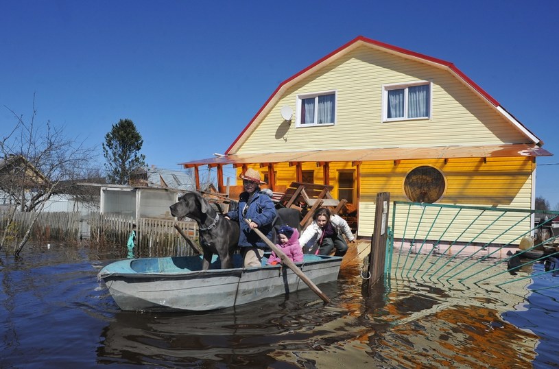 Na zdjęciu powodzianie opuszczają zalany dom /Olga Maltseva /AFP