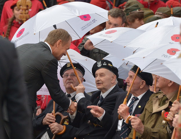 Na zdjęciu premier Donald Tusk (z lewej) wita się z kombatantami w trakcie uroczystości na dziedzińcu opactwa Benedyktynów /Radek Pietruszka /PAP