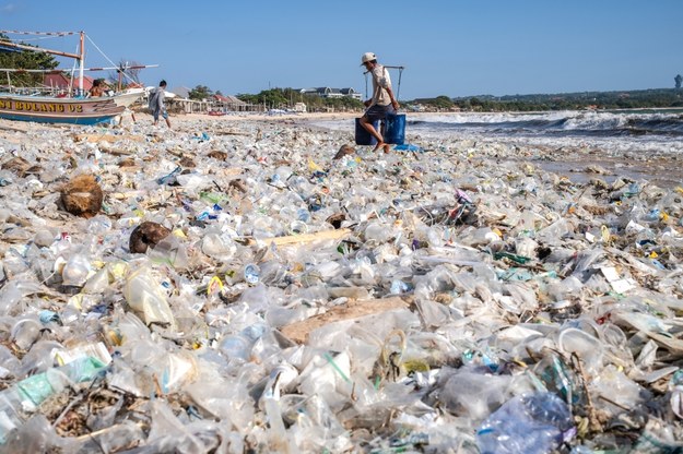 Na zdjęciu z plaży Kedonganan widać mężczyznę, wynoszącego śmieci w wiaderkach /MADE NAGI    /PAP/EPA