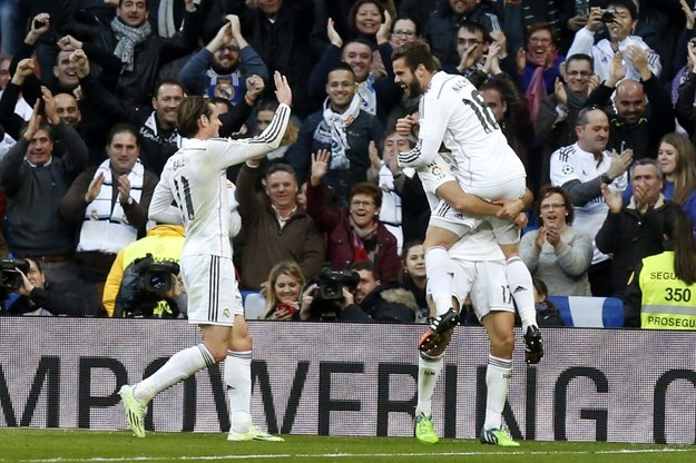 Nacho Fernandez (po prawej) z Realu Madryt cieszy się ze strzelenia gola w meczu z Espanyolem. W środku: Alvaro Arbeloa, po lewej: Gareth Bale /JUAN CARLOS HIDALGO    /PAP/EPA