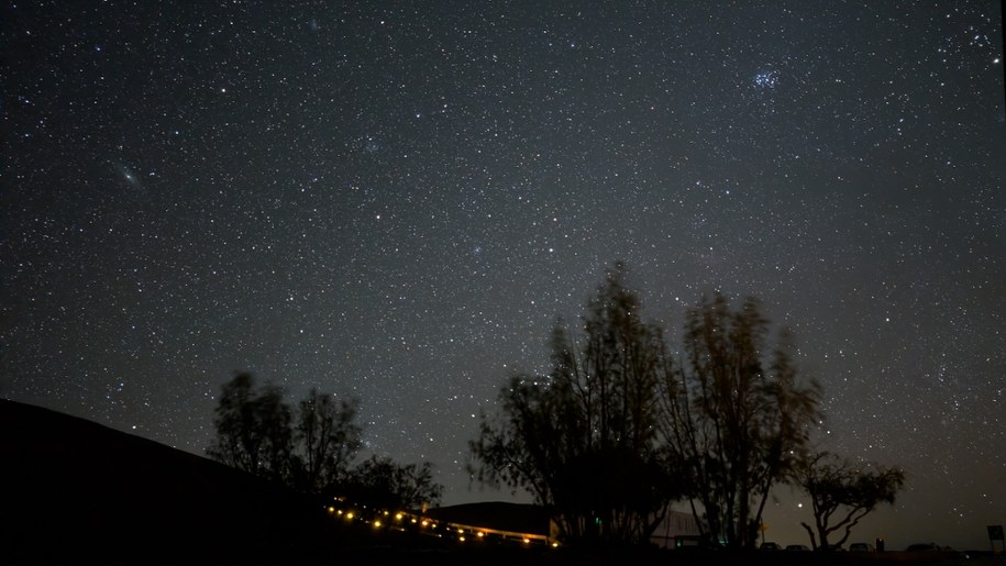 Niebo nad Paranal. na skraju po prawej u góry - Aldebaran, najjaśniejsza gwiazda konstelacji Byka. Nieco w lewo, Plejady. Na dole wśród drzew Kapella, szósta po wzgledem jasności gwiazda na nocnym niebie. Po lewej  Mgławica Andromedy. /Fot. Grzegorz Jasiński /RMF FM