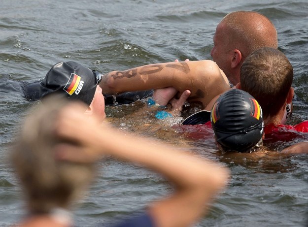 Niemieccy pływacy Finnia Wunram i Angela Maurer asystują ratownikom przy wyciąganiu Natalii Charłos z wody /TIM BRAKEMEIER /PAP/EPA