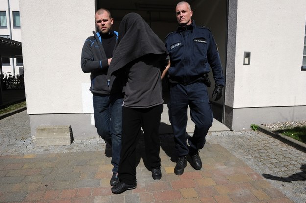 Niemieccy policjanci wyprowadzają z aresztu zatrzymanego Adriana M. /Marcin Bielecki /PAP