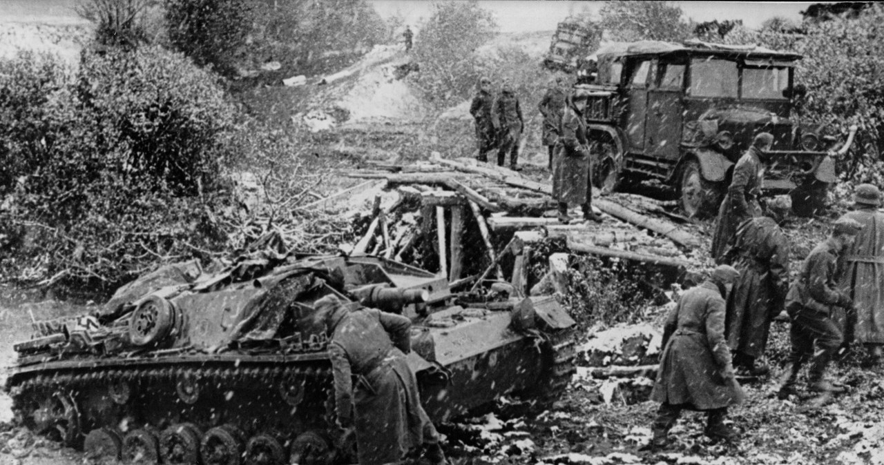 Niemieckie działo samobieżne StuG III przejeżdża przez błotnisty teren na froncie wschodnim. Widoczna także ciężarówka jadąca po drewnianym moście /Z archiwum Narodowego Archiwum Cyfrowego