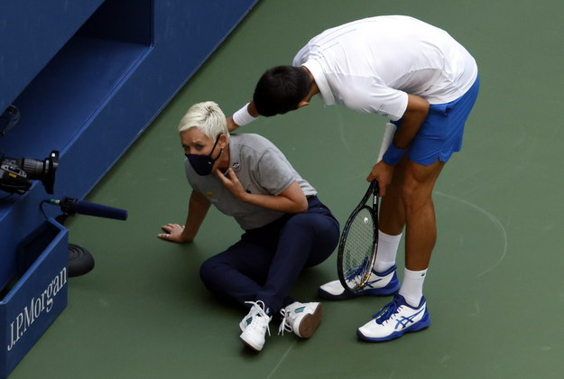 Novak Djokovic próbuje pomóc sędzi liniowej, którą przez przypadek uderzył piłką /JASON SZENES    /PAP/EPA