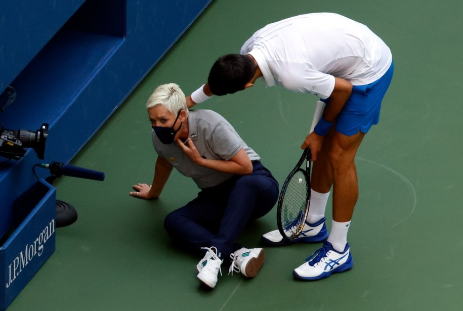 Novak Djokovic próbuje pomóc sędzia liniowemu, który przypadkowo uderzył piłkę / JASON SZENES / PAP / EPA