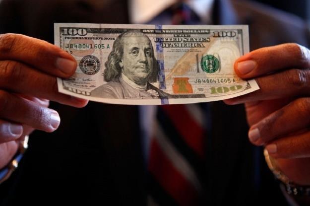 Nowe banknoty studolarowe mają jasnoniebieski "pasek bezpieczeństwa" /AFP