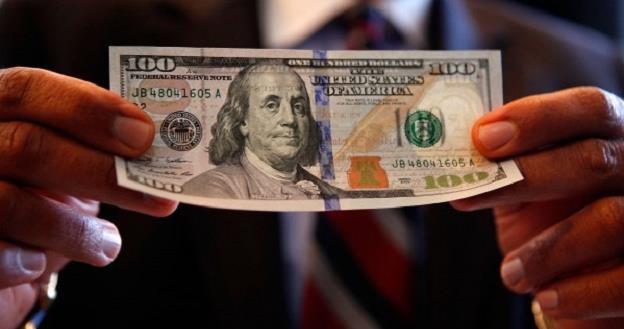 Nowe banknoty studolarowe mają jasnoniebieski "pasek bezpieczeństwa" /AFP