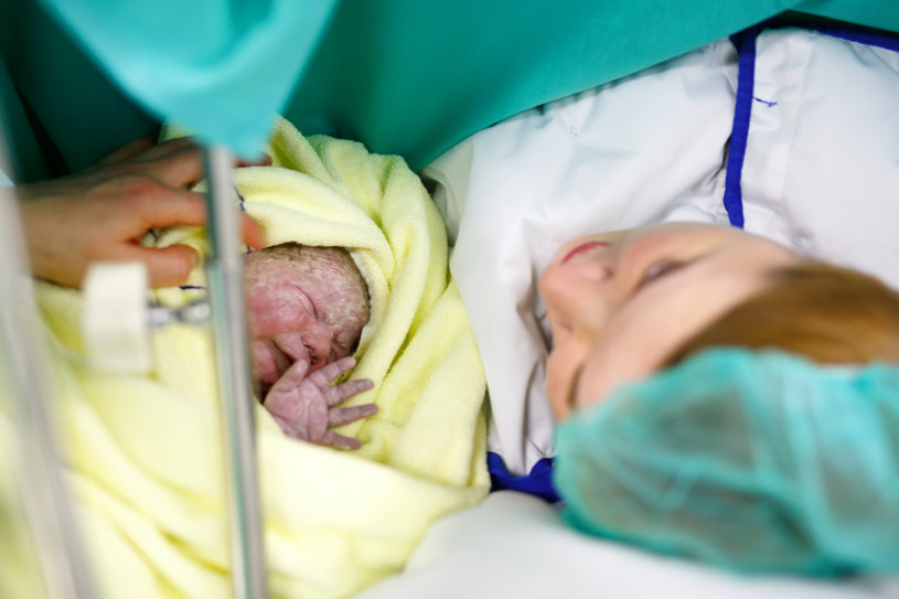 Noworodek urodzony cięciem cesarskim, po ocenie jego stanu zdrowia przez neonatologa, jest przystawiany do twarzy matki /123RF/PICSEL
