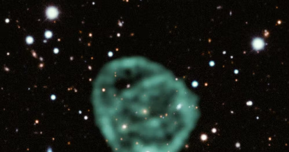 Obraz kręgu radiowego Odd ORC J2103-6200 wykonany przez teleskop MeerKAT nałożony na obraz optyczny z przeglądu Dark Energy Survey (2022). /Jayanne English MeerKAT/CC BY-SA 4.0 /Wikimedia