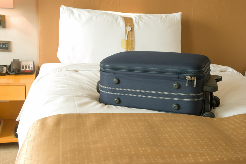 Od razu po wejściu do pokoju rzucasz walizkę na łóżko? Wielu odradza taki nawyk /123RF/PICSEL