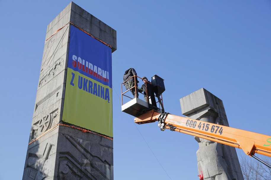 Olsztyn, 2 marca 2022. Aktywiści stowarzyszenia Święta Warmia wieszają na pomniku Wyzwolenia Ziemi Warmińskiej i Mazurskiej (dawnym pomniku Wdzięczności Armii Czerwonej), baner "Solidarni z Ukrainą" / 	Tomasz Waszczuk    /PAP