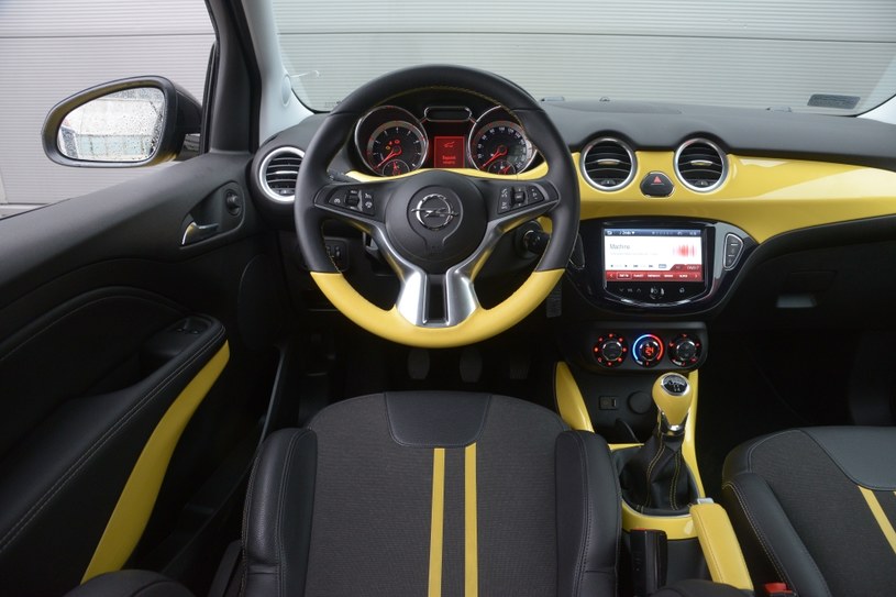 Opel Adam 1.2 Ecotec Jam: od drugiej wersji wyposażenia kierownica ma dwuosiową regulację. Panel klimatyzacji umieszczono nieco za nisko. Jedynie lakierowane elementy deski rozdzielczej Opla stanowią nawiązania do Fiata. /Motor