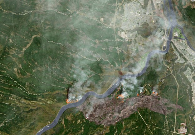 Opublikowane przez NASA zdjęcie satelitarne terenów objętych pożarem, w prawym górnym roku widać Fort McMurray. Aktywne pożary widać na zdjęciu jako czerwone plamy, z kolei miejsca brązowe to tereny już zniszczone w pożarze /NASA/EARTH OBSERVATORY/JOSHUA STEVENS HANDOUT /PAP/EPA