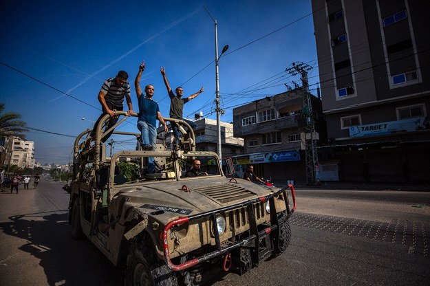 Palestyńczycy stojący na zdobycznym izraelskim pojeździe /HAITHAM IMAD /PAP/EPA