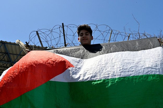 Palestyńska flaga na tle ogrodzenia z drutem kolczastym /WAEL HAMZEH /PAP/EPA