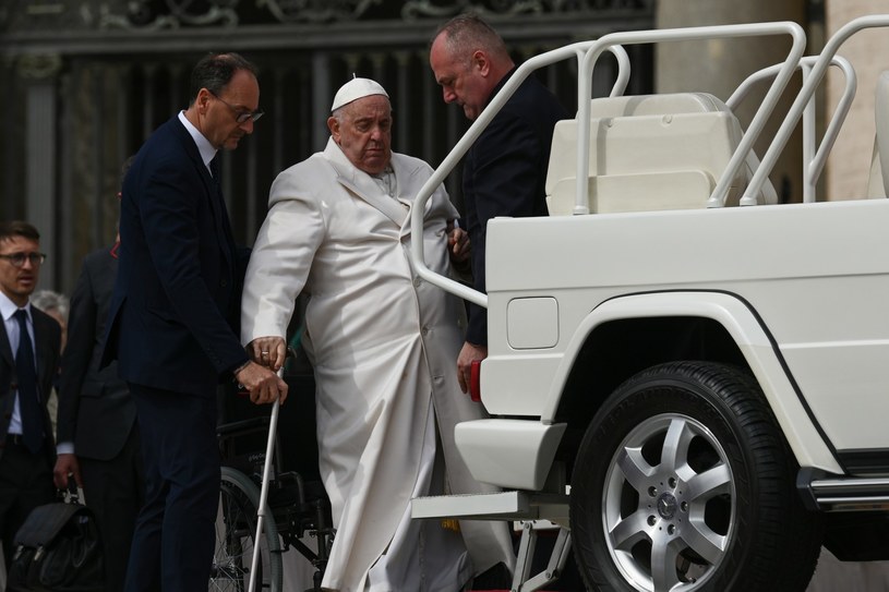 Papież Franciszek, któremu udzielana jest pomoc przy wchodzeniu do papamobile, podczas środowej audiencji generalnej na placu św. Piotra /VINCENZO PINTO /AFP