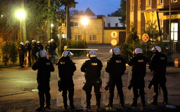 Patrolujący miasto z góry śmigłowiec i w możone siły policji w pobliżu miejscowego komisariatu są widoczne wieczorem w Knurowi /Andrzej Grygiel /PAP