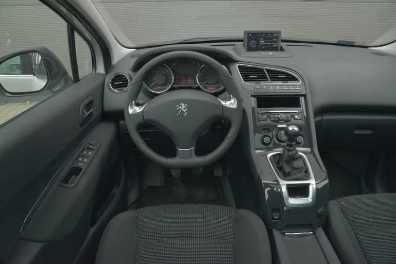 Peugeot 5008 2.0 HDi 150 Allure: na kierownicy nie ma przycisków zestawu audio, ale pod nią jest wygodny joystick. Świetne umiejscowienie przekładni zmiany biegów i tylko jeden uchwyt na kubek. Wysoka jakość górnej części kokpitu. /Motor