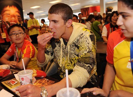 Phelps (w środku) objada się w sieci fast foodu, której jest ambasadorem. Pekin, 18 sierpnia 2008 /AFP