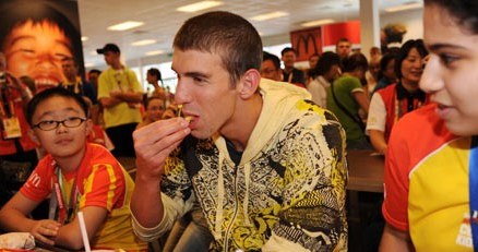 Phelps (w środku) objada się w sieci fast foodu, której jest ambasadorem. Pekin, 18 sierpnia 2008 /AFP