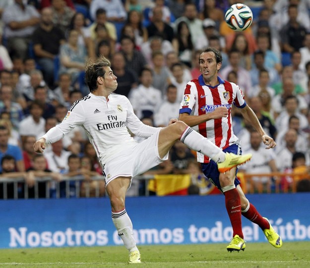 Piłkarz Realu Madryt Gareth Bale (L) i zawodnik Atletico Madryt Diego Godín (P) /KIKO HUESCA /PAP/EPA