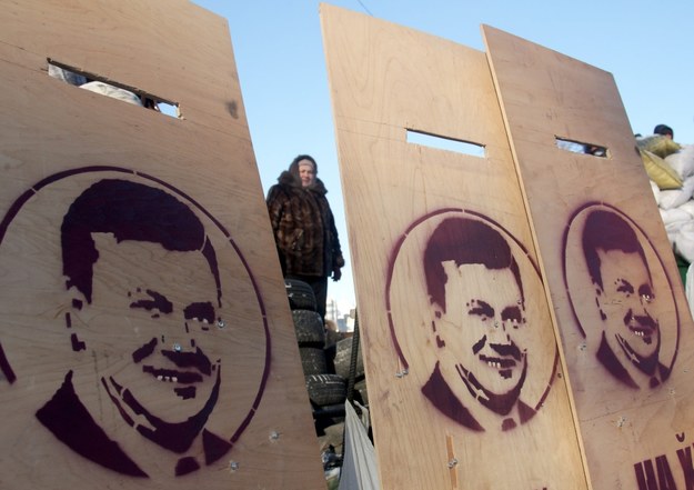 Podobizny prezydenta Wiktora Janukowycza na drewnianych tarczach trzymanych przez przeciwników władz /ZURAB KURTSIKIDZE /PAP/EPA
