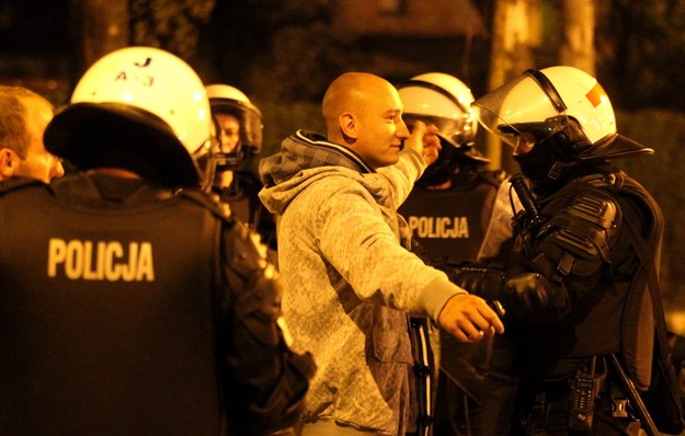 Policjanci przeszukują pseudokibiców, którzy próbowali wzniecić zamieszki przed komisariatem policji w Knurowie /Andrzej Grygiel /PAP