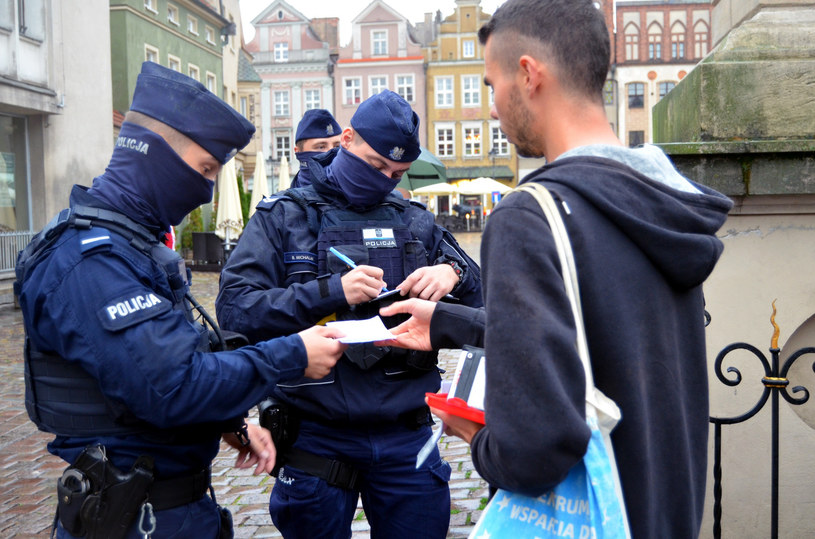 Policjanci wypisują mandat za brak maseczki /Norbert Rzepka /Reporter