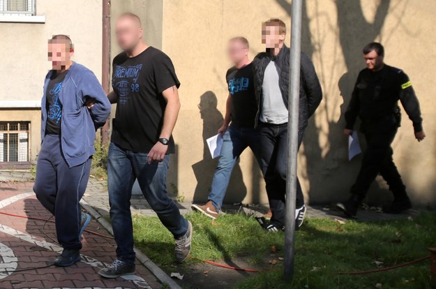 Policjanci wyprowadzają z Komendy Miejskiej Policji w Chorzowie dwóch mężczyzn podejrzanych o podłożenie ładunku zapalającego na stadionie chorzowskiego Ruchu /Andrzej Grygiel   (PAP) /PAP