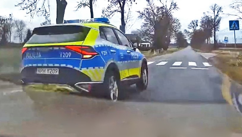Policjant za kierownicą oznakowanej Kii Sportage wyprzedził inny pojazd tuż przed przejściem dla pieszych /YouTube/STOPcham /