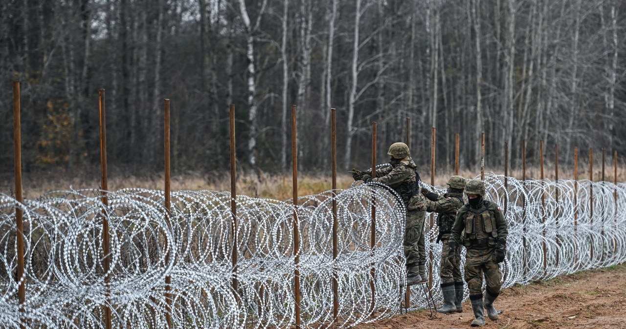 Polscy żołnierze rozkładający mur z drutu kolczastego na granicy polsko-białoruskiej /OMAR MARQUES / ANADOLU / Anadolu via AFP /AFP