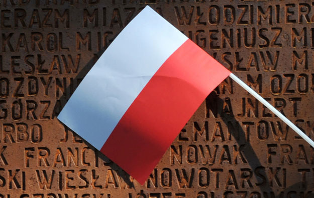 Polska flaga na tle pomnika pomordowanych przez Sowietów polskich oficerów w Charkowie /AFP