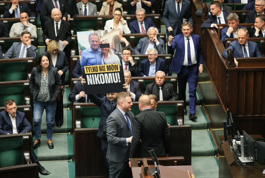 Poseł PiS Dariusz Matecki z planszą z fotografią premiera Donalda Tuska w towarzystwie byłej działaczki PO Kamili L., 55. posiedzenie Sejmu; Warszawa, 17 kwietnia 2026 roku /Dawid Wolski/East News /East News