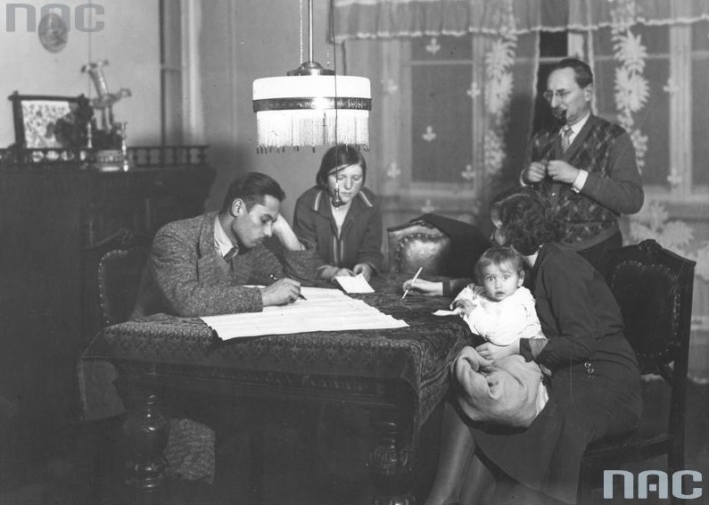 Powszechny Spis Ludności (zdjęcie z 1931 roku): Rodzina z pomocą komisarza spisowego wypełnia arkusz spisowy. /Z archiwum Narodowego Archiwum Cyfrowego