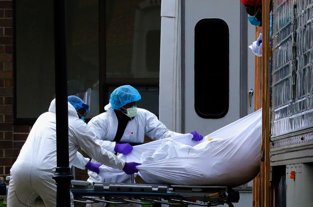 Pracownicy medyczni wyjmują ciało ofiary koronawirusa z ciężarówki-chłodni, Nowy Jork /Peter Foley /PAP/EPA