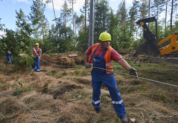 Pracownicy pogotowia energetycznego naprawia zerwaną linię średniego napięcia /Dominik Kulaszewicz /PAP